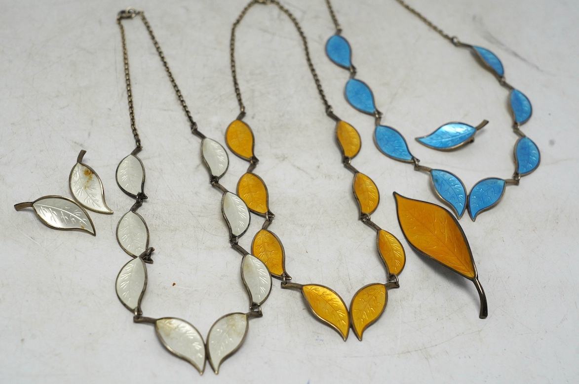 Seven items of David Andersen sterling and enamel jewellery, including necklace and pair of earrings in cream enamel, necklace and one earring in blue and a necklace and brooch in yellow, largest necklace 40cm. Condition